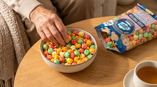senior-hands-reaching-for-high-protein-popcorn-on-table