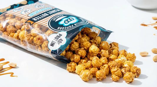 high-protein-popcorn-bags-and-popped-kernels-on-clean-white-tabletop