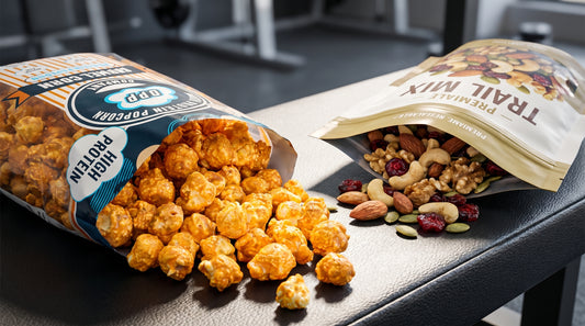 protein-popcorn-and-trail-mix-comparison-on-gym-bench-high-protein-snack-visual